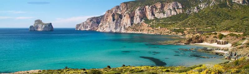 Una vista sul paesaggio marino dell'insenatura di Masua con una vista sullo scoglio di Pan di Zucchero